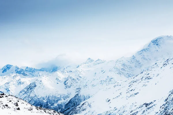 Picos de montaña cubiertos de nieve al atardecer . —  Fotos de Stock