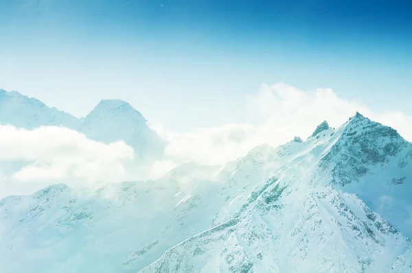 Picos de montaña cubiertos de nieve al atardecer . —  Fotos de Stock