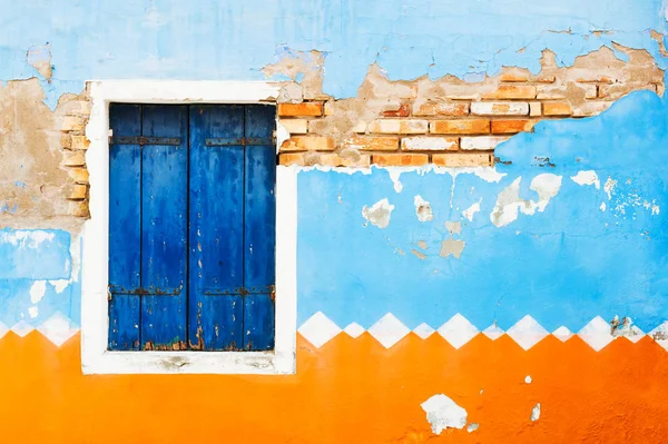 Древняя стена дома и окно с голубыми ставнями . — стоковое фото