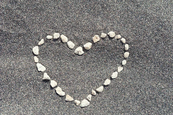 Herz auf dem schwarzen Sand. — Stockfoto