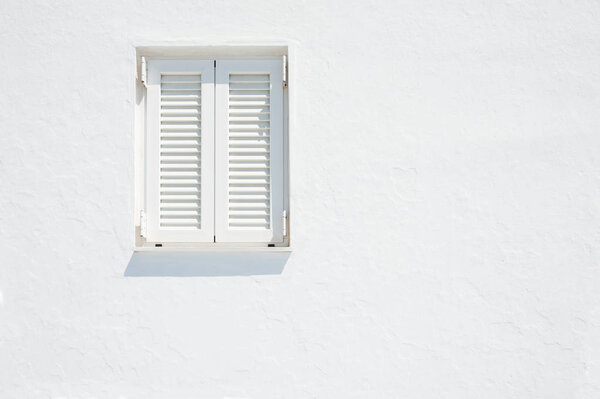 White wall and window with white shutters. Santorini island, Greece.