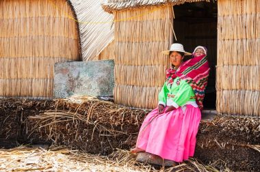 Kadın Uros yüzen ada Titicaca gölü üzerinde bir çocukla