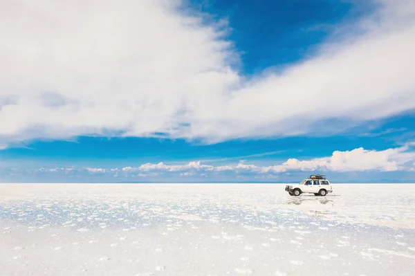 Terénní auto projíždí sůl plochý Salar de Uyuni v Bol — Stock fotografie