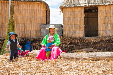 Titicaca gölü Uros yüzen adalarda çocuklu kadınla