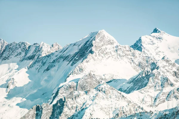 Picos de montaña cubiertos de nieve en invierno . — Foto de Stock
