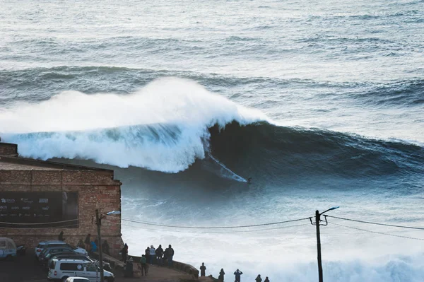 Surfer rijdt op een grote golf van 15 meter in Nazare, Portugal. — Stockfoto