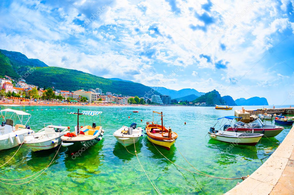 Port with boats and beautiful beach in Petrovac, Montenegro.