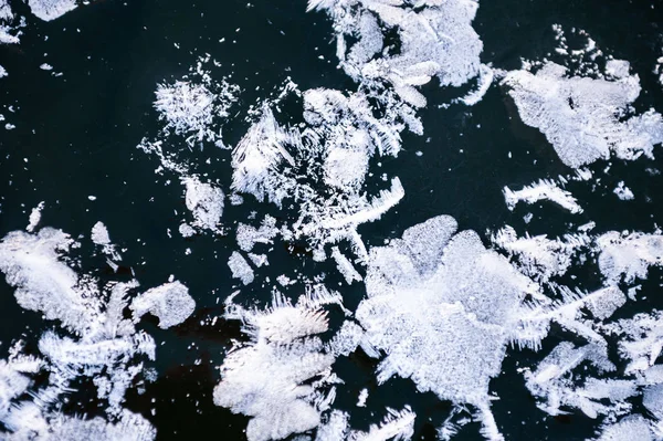 Witte ijzel op het oppervlak van het ijs op het meer. — Stockfoto