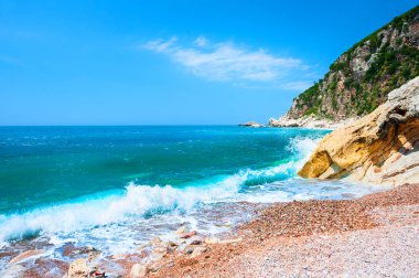 Güzel bir plaj turkuaz su ve kayalıklarla 