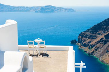 Terasta deniz manzaralı iki sandalye. Santorini Adası, Yunanistan 'da beyaz mimari. Seyahat hedefleri kavramı