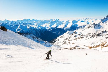Kayakçı Alp dağlarında yamaçtan aşağı iniyor. Kış sporu. Val Thorens, 3 vadi, Fransa. Güzel dağlar, kış manzarası
