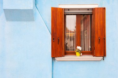 Mavi duvarında ahşap panjurlar olan pencere. Burano Adası, Venedik, İtalya 'da renkli mimari.