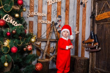 Noel Baba'nın kostüm Xmas ağacı yakınındaki mutlu küçük bebek