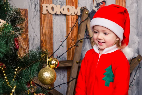 Bebé feliz disfrazado de Santa Claus cerca del árbol de Navidad — Foto de Stock