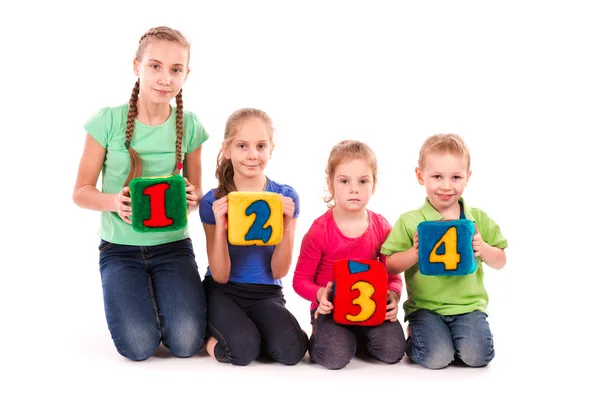 Niños felices sosteniendo bloques con números sobre fondo blanco — Foto de Stock