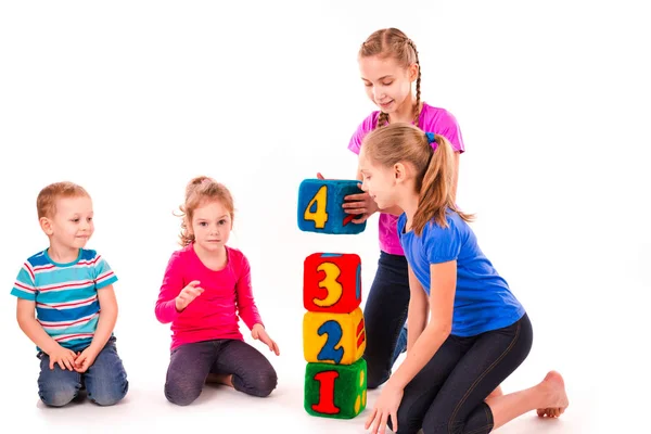 Niños felices sosteniendo bloques con números sobre fondo blanco —  Fotos de Stock