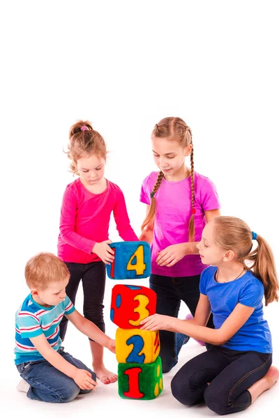 Niños felices sosteniendo bloques con números sobre fondo blanco — Foto de Stock