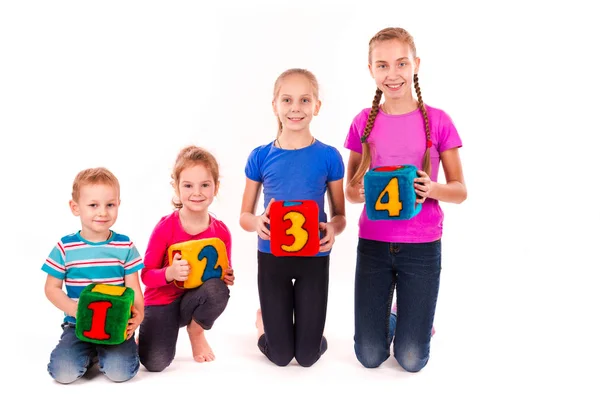 Bambini felici che tengono blocchi con numeri su sfondo bianco — Foto Stock