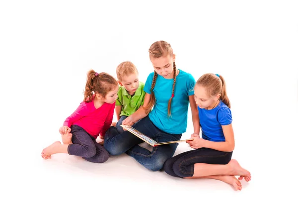 Crianças felizes lendo um livro isolado no branco — Fotografia de Stock