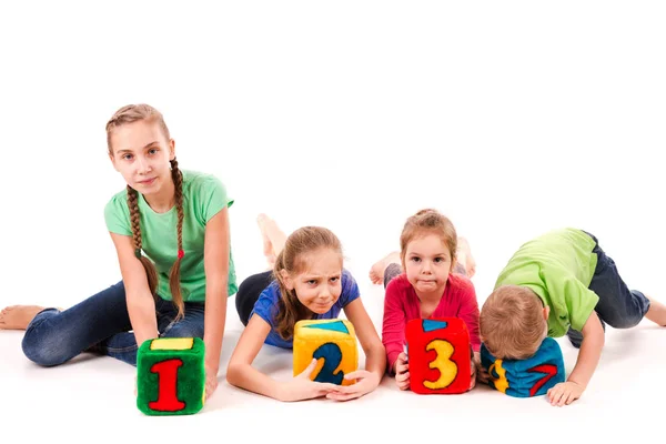 Niños felices sosteniendo bloques con números sobre fondo blanco — Foto de Stock