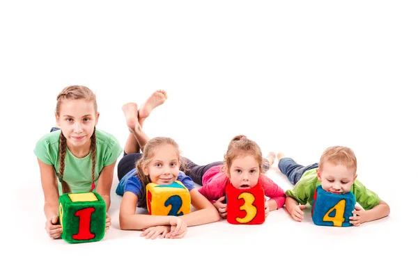 Niños felices sosteniendo bloques con números sobre fondo blanco —  Fotos de Stock