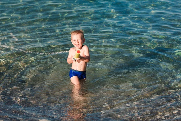 Su tabancasıyla oynayan sevimli mutlu çocuk — Stok fotoğraf