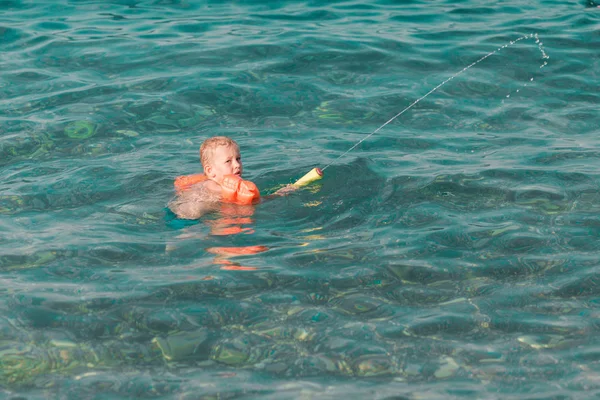 Schattige gelukkige jongen spelen met water pistool — Stockfoto