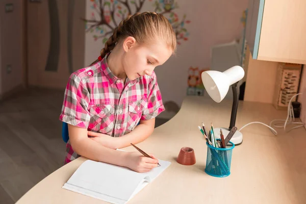 Симпатична маленька дівчинка пише домашнє завдання — стокове фото