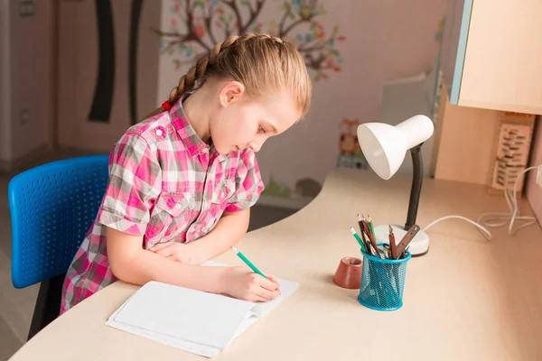 Bonita menina escrevendo seu dever de casa — Fotografia de Stock