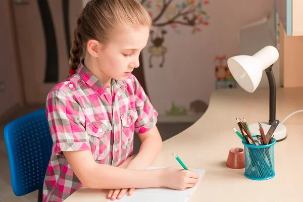 Cute little girl writing her homework — Stock Photo, Image