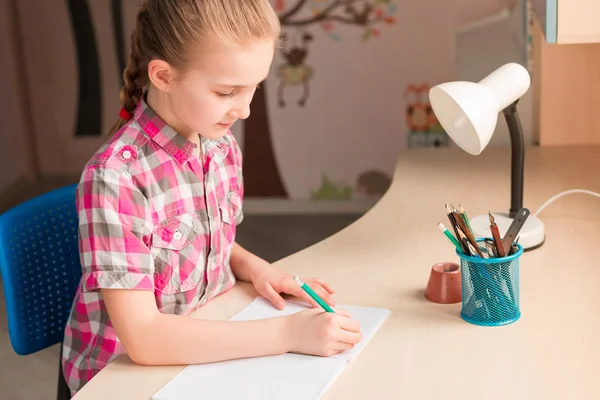 Cute little girl writing her homework — Stock Photo, Image