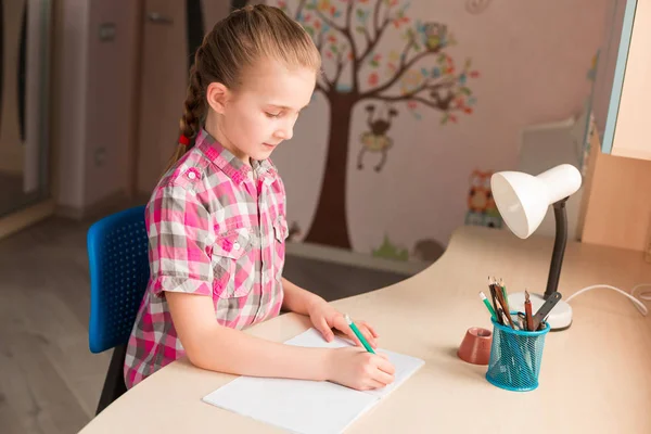 Cute little girl writing her homework — Stock Photo, Image