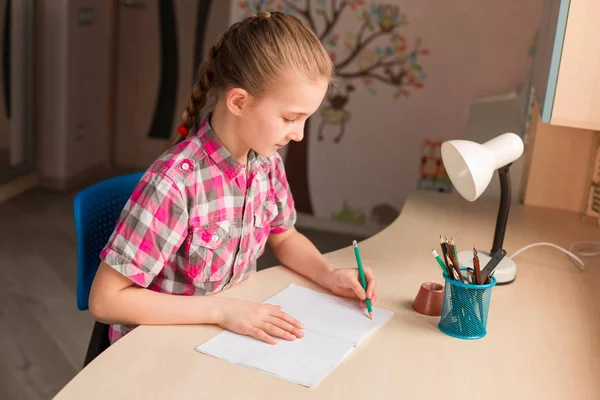 Cute little girl writing her homework — Stock Photo, Image