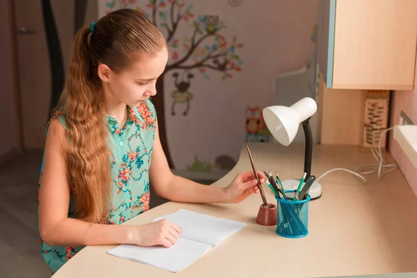 Cute little girl writing her homework — Stock Photo, Image