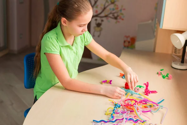 Söta lilla flicka skapa leksaker med chenille pinnar — Stockfoto