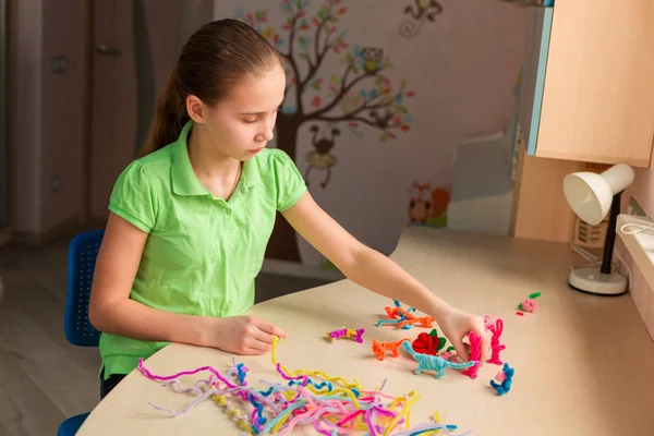 Симпатична маленька дівчинка створює іграшки з паличками ченіл — стокове фото