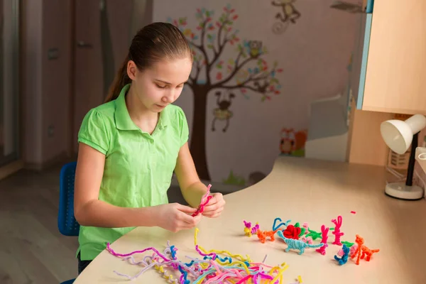 Cute little girl creating toys with chenille sticks — Stock Photo, Image