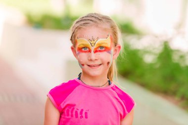 Küçük kızla mutlu yüz sanat boya Park.
