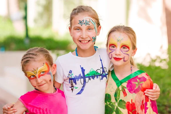 Niñas felices con pintura de arte facial en el parque . — Foto de Stock