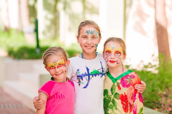 Happy little girls with face art paint in the park. — Stock Photo, Image