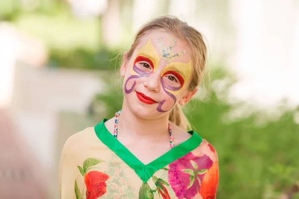 Happy little girl with face art paint in the park. — Stock Photo, Image