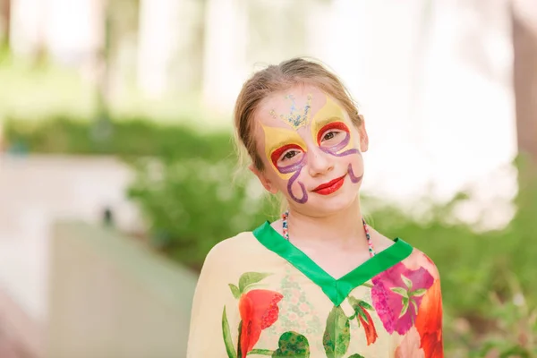 Happy little girl with face art paint in the park. — Stock Photo, Image