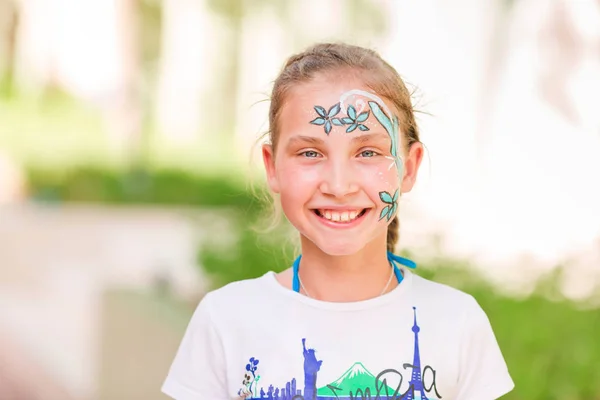 Gelukkig klein meisje met gezicht schilderen van de kunst in het park. — Stockfoto