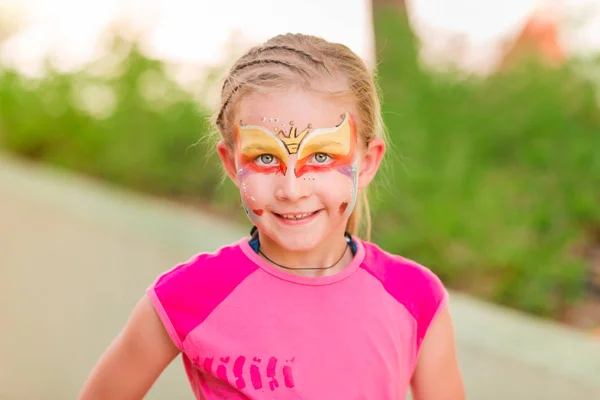 Gelukkig klein meisje met gezicht schilderen van de kunst in het park. — Stockfoto