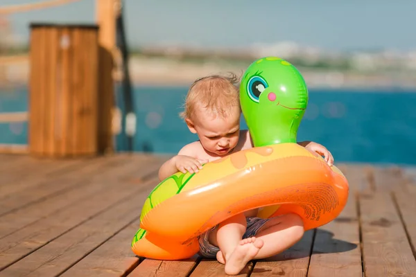 Lindo niño jugando con la boya de la vida en la playa —  Fotos de Stock