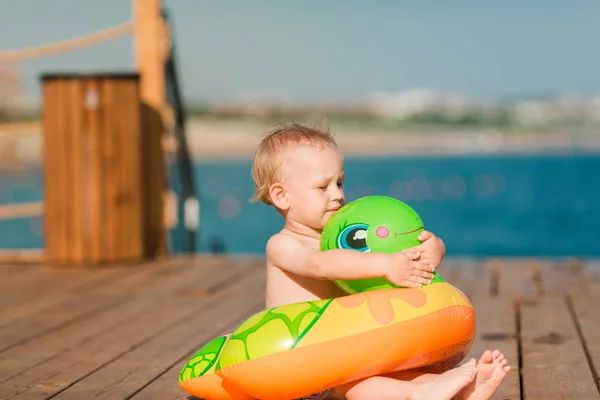 Милый маленький мальчик играет с буем на берегу моря — стоковое фото