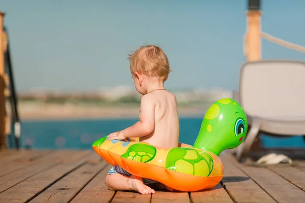 Lindo niño jugando con la boya de la vida en la playa — Foto de Stock