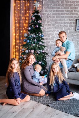 Mutlu aile Noel ağacının yanında eğleniyor.