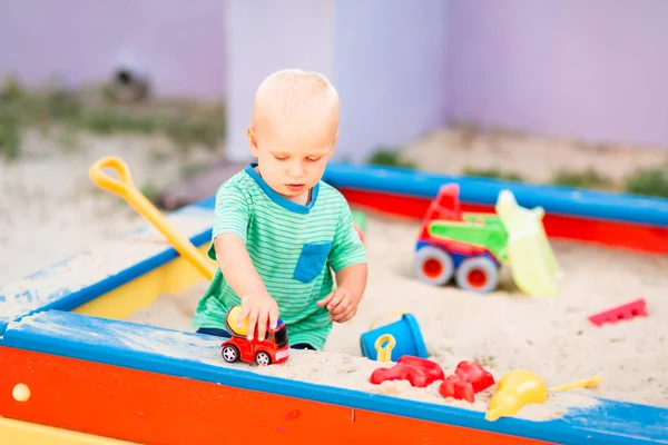 Cute baby boy playing in the sandbox — Stock Photo, Image