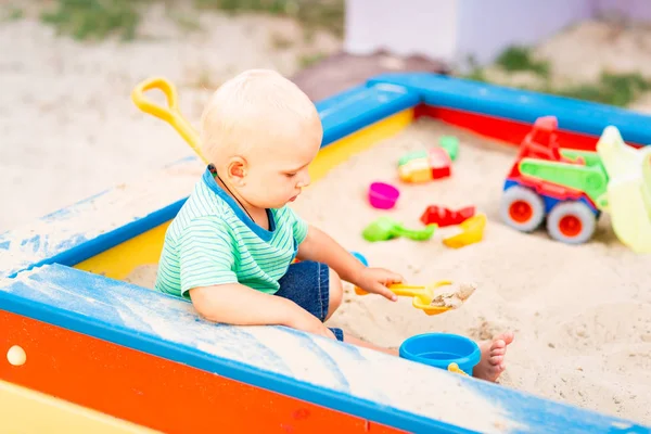 Милый мальчик играет в песочнице — стоковое фото